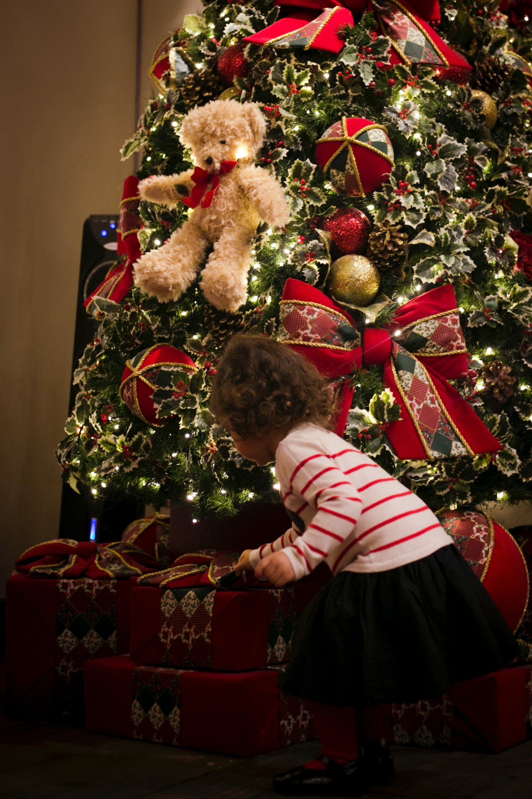 girl picking gift in front of pre-lit tree