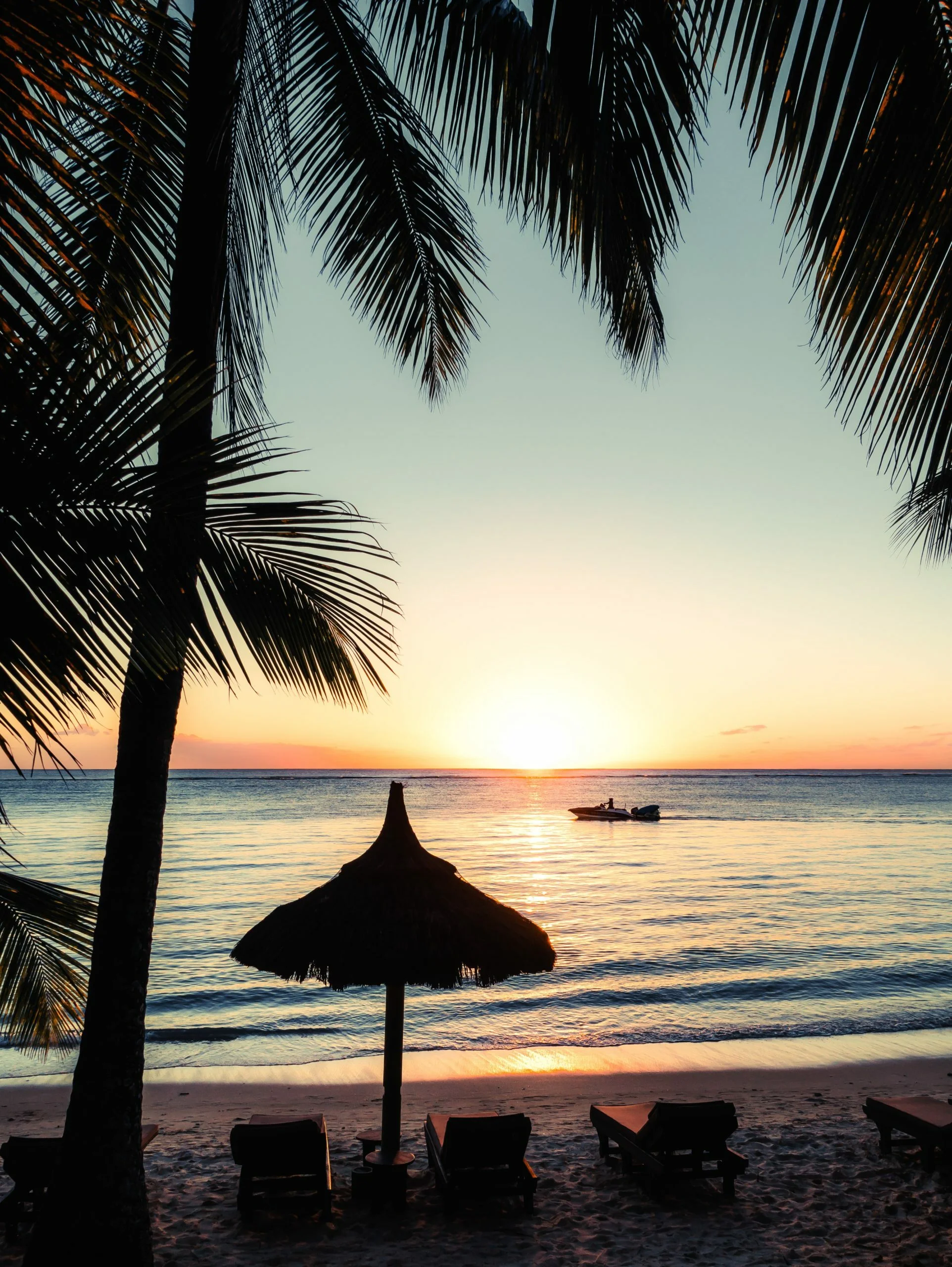 silhouette photo of boat near outdoor loungers