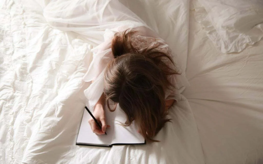 woman lying on white bed