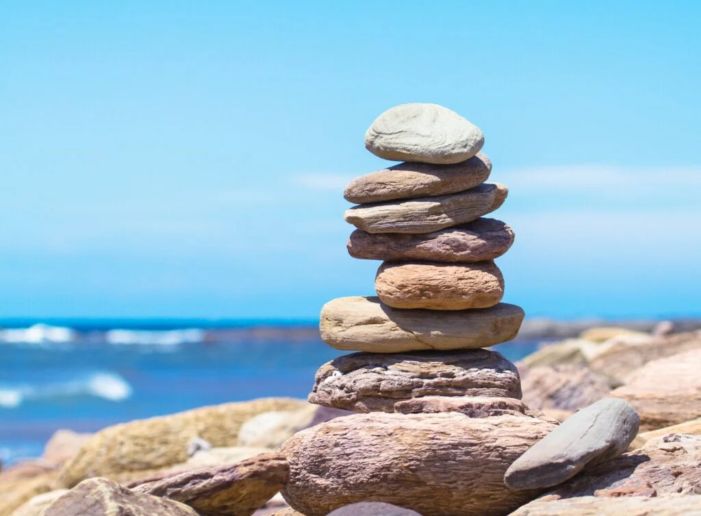 The karmic cycle can be compared to a pile of stones on the beach, each rock representing a past action or thought. Over time, as we continue to add stones to the pile, it grows taller and heavier, making it harder to move or change course. But just like a pile of stones, our karma is not permanent.