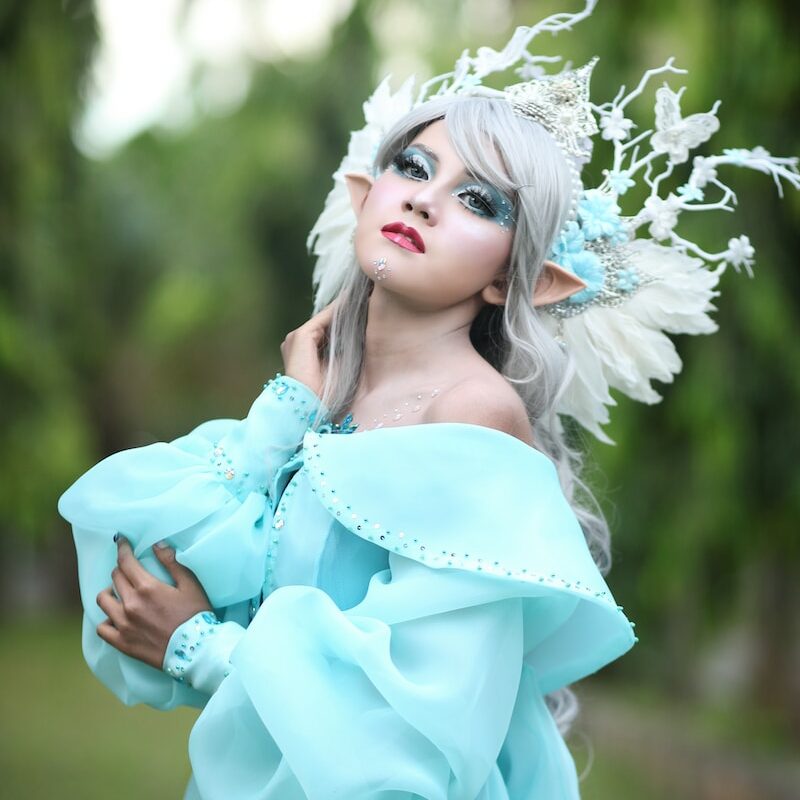 a woman in a blue dress with white feathers
