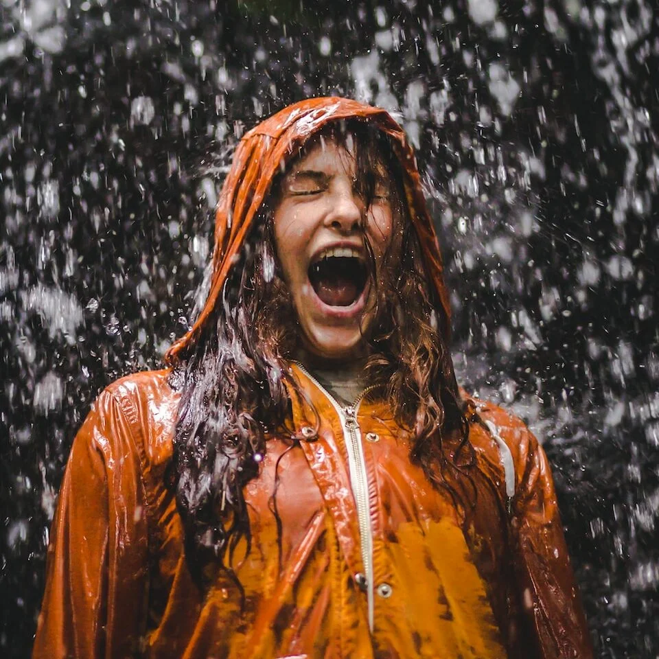 close-up photo of woman in orange coat