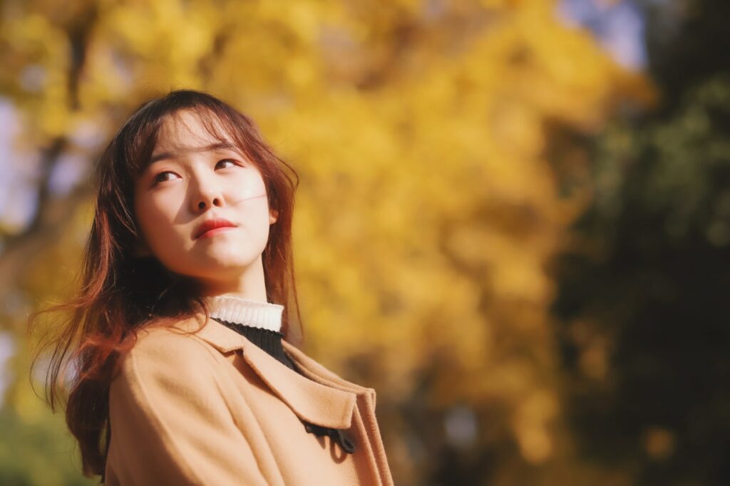 a woman standing in front of a tree