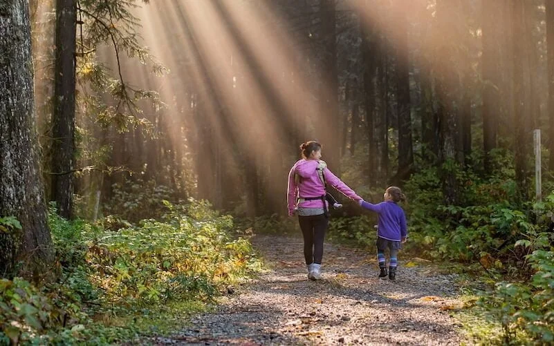 woman walking in forest with child