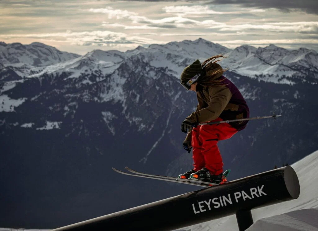 man in red jacket and blue pants riding on snowboard on snow covered mountain during daytime