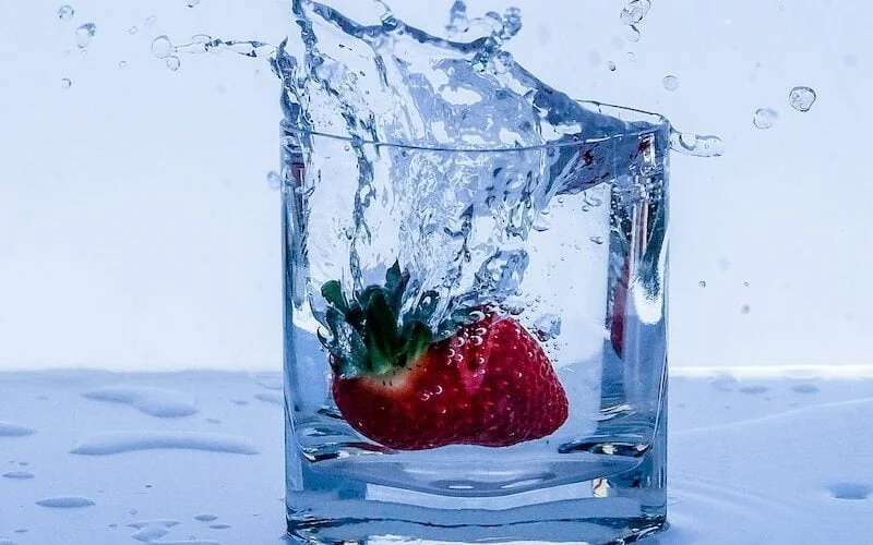 red strawberry in clear glass container
