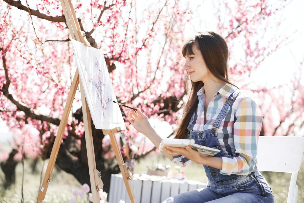 a woman sitting on a bench in front of a painting