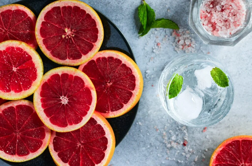 a plate of grapefruits and a glass of water