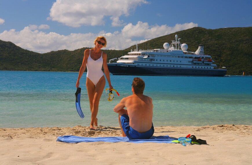 Vacationers enjoying a pristine beach with the majestic luxury cruise ship anchored in the background, representing the unforgettable experiences of luxury cruises.