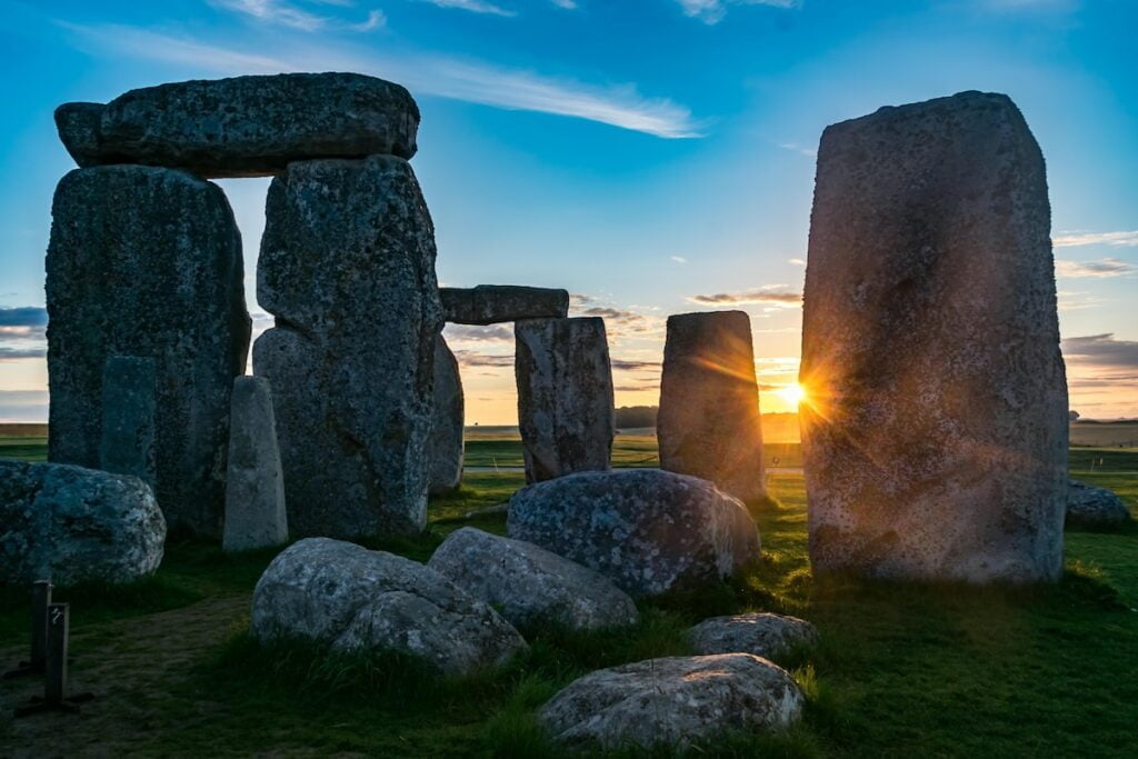the sun is setting behind the stonehenge monument