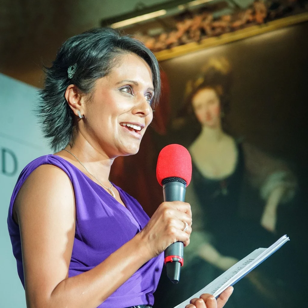 Arti Halai, seasoned broadcaster and entrepreneur holding a microphone while giving a talk