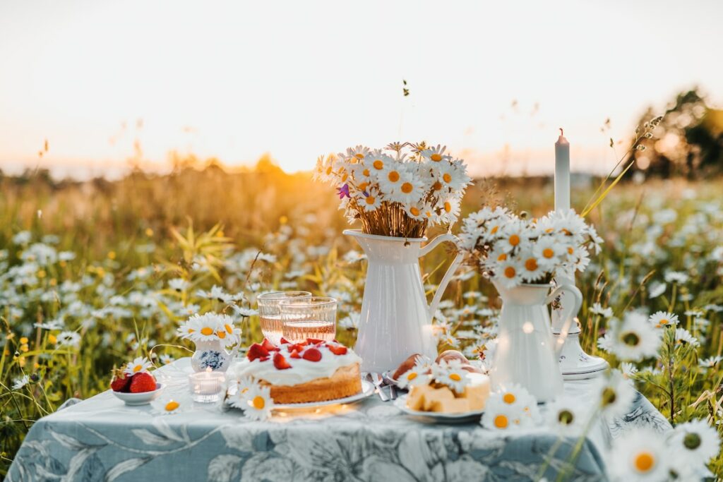a table topped with a cake covered in daisies
