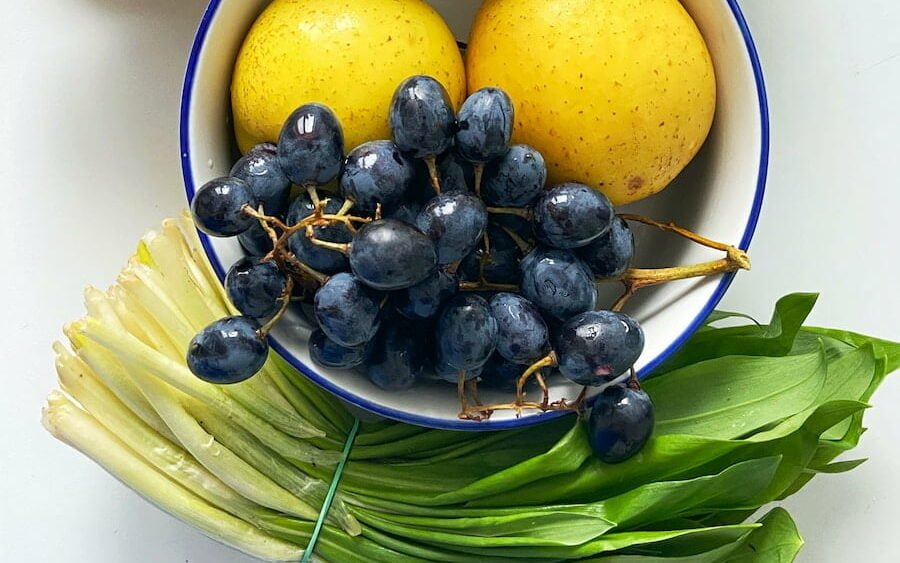 yellow banana and blue berries in blue ceramic bowl