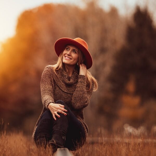 woman sitting on grass field and smiling