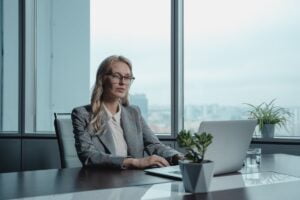 Woman in Gray Blazer Sitting by the Table