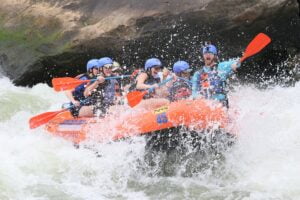 people riding orange kayak on water during daytime