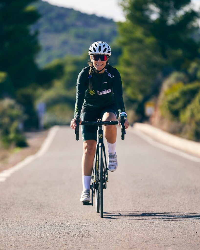 a woman riding a bike down a curvy road