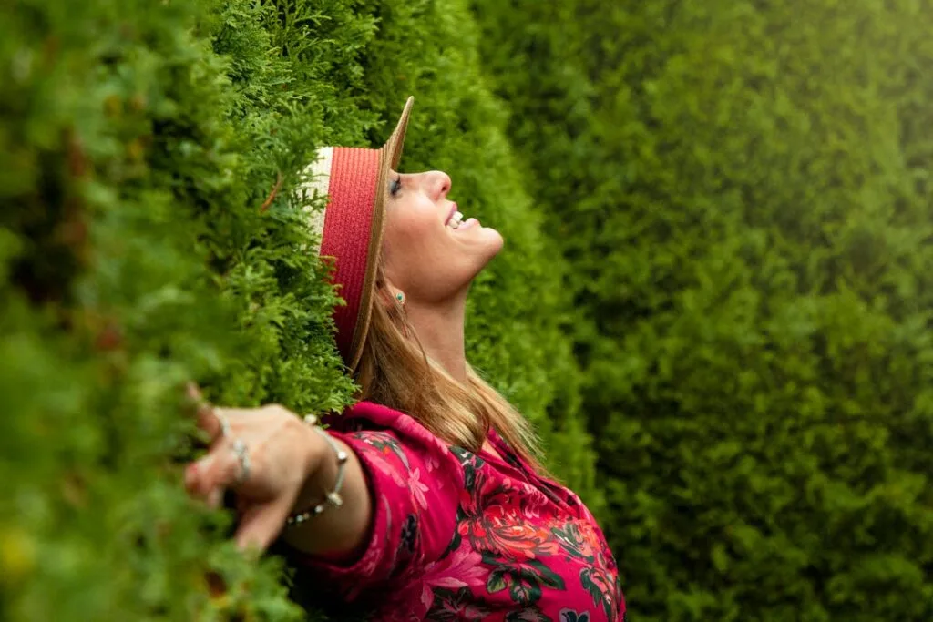A joyful woman enjoying nature, embracing freedom in a lush green park.