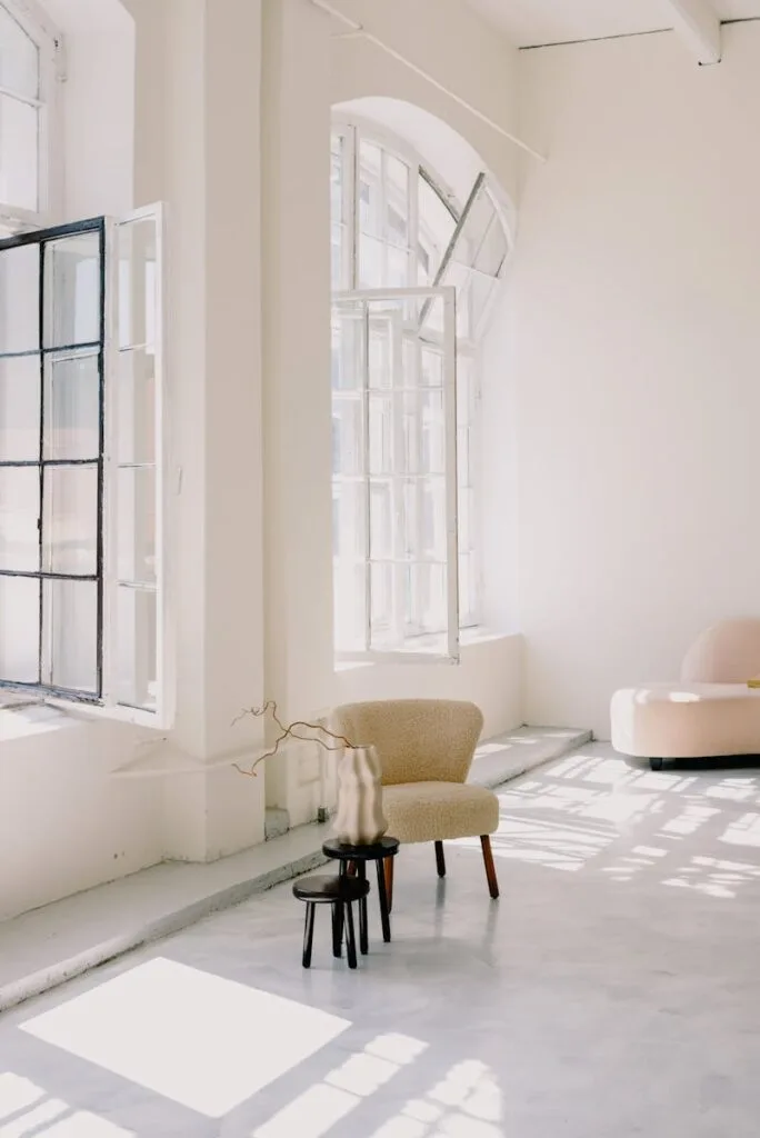 Minimalist interior design featuring large windows, soft lighting, and contemporary furniture.