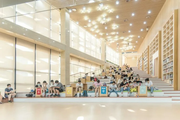 a group of people sitting on the steps of a library