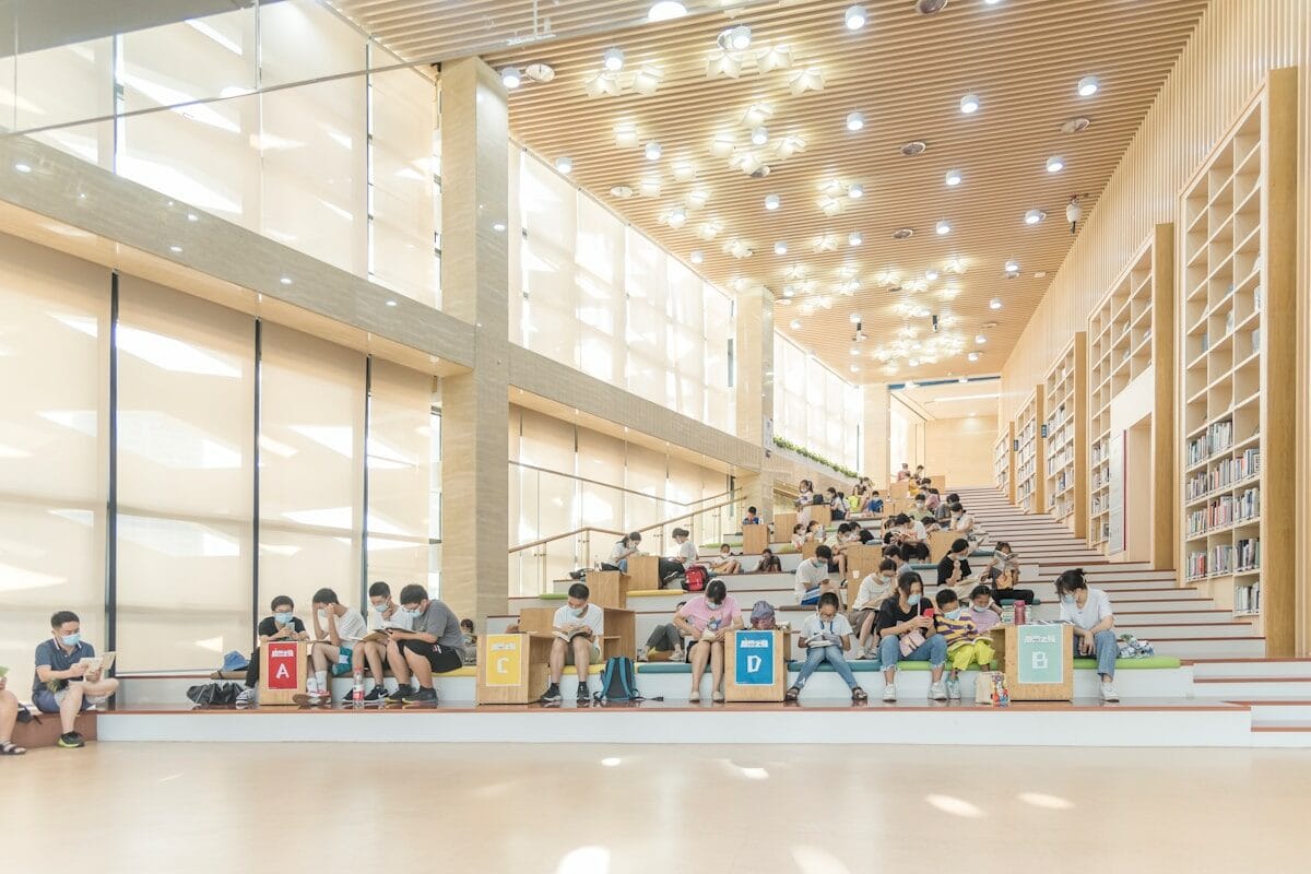 a group of people sitting on the steps of a library
